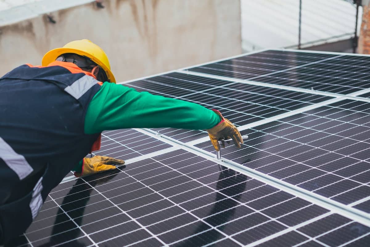 amortizare panouri fotovoltaice - un electrician monteaza panouri solare pe un acoperis de casa