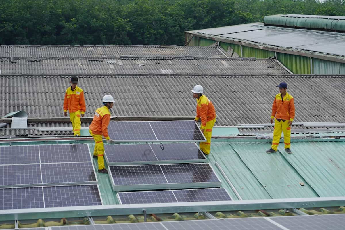 extindere sistem fotovoltaic - mai multi muncitori instaleaza un sistem fotovoltaic pe un acoperis