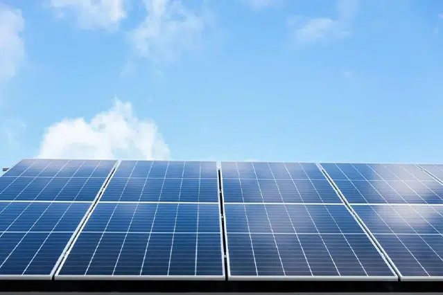 Panouri fotovoltaice de mari dimensiuni instalate pe acoperiș, captând energia solară într-o zi senină