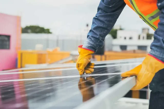 Montaj panouri fotovoltaice pe acoperiș – câte sunt necesare pentru o centrală electrică Tehnician care instalează panouri fotovoltaice pe un acoperiș, parte din procesul de dimensionare a unei centrale electrice solare